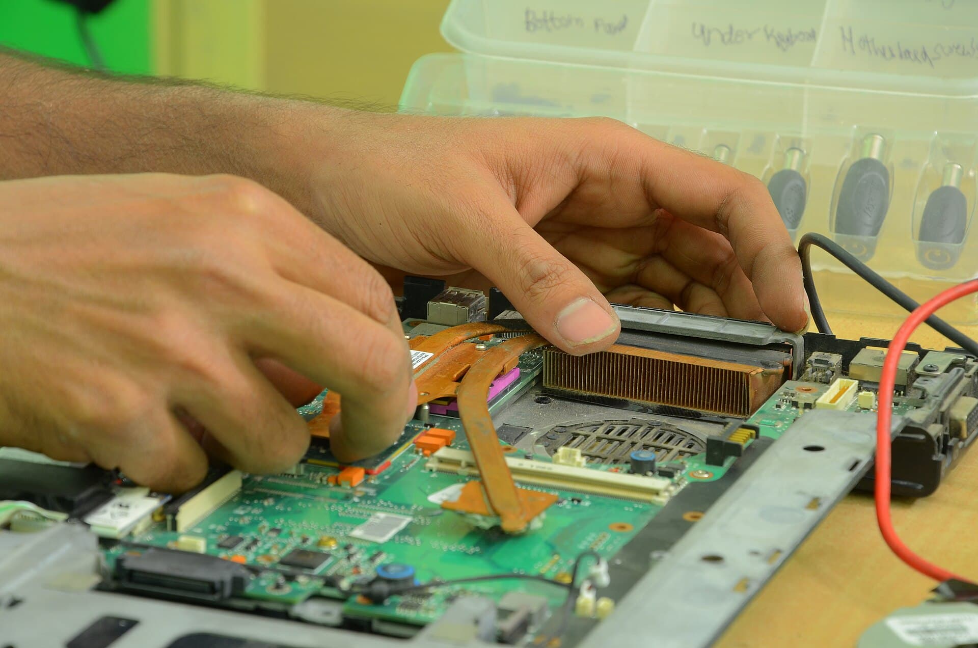 Technician repairing computer hardware at a workbench